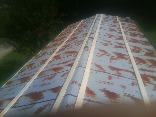Rusted metal roof panels with new wood purlins before replacement — Storm Damage Roof Repair in Williamsville by Roofing Brothers